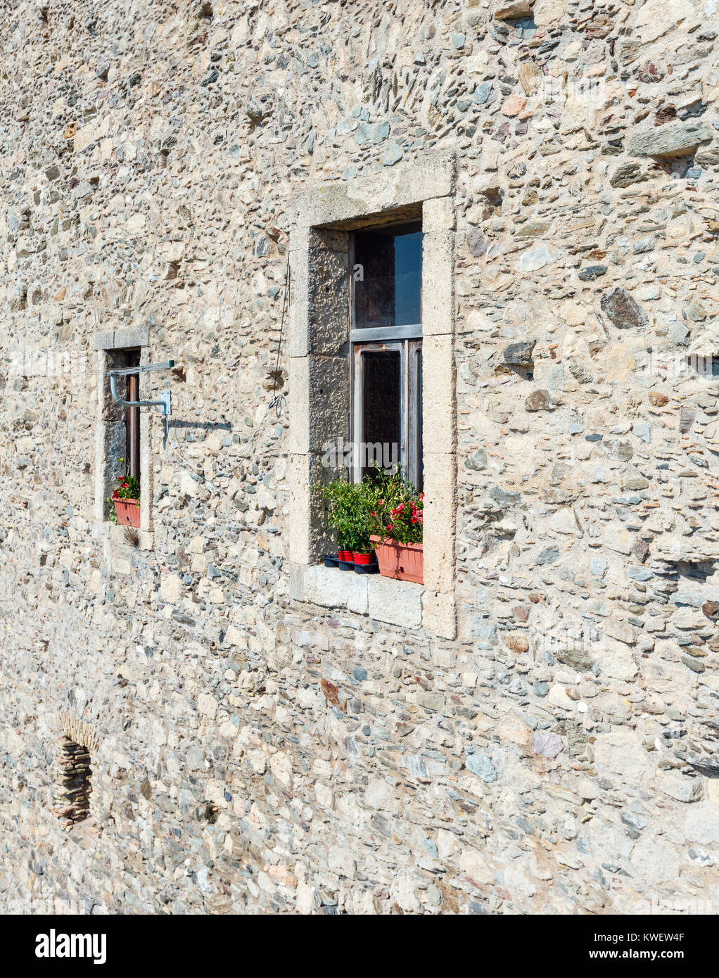 Window with home plants in old beautiful stony house (Fiumefreddo Bruzio - one of Italy Most Beautiful Villages, on mountain hill top above Tyrrhenian Stock Photo
