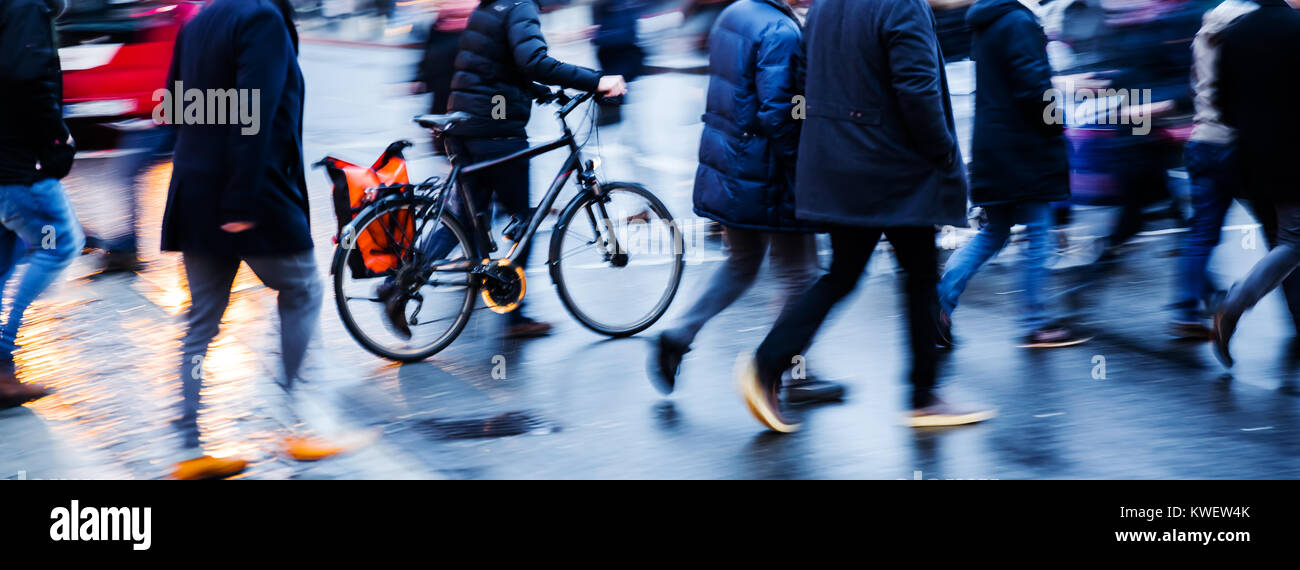 motion blur picture of people and bicycle crossing a city street at ...