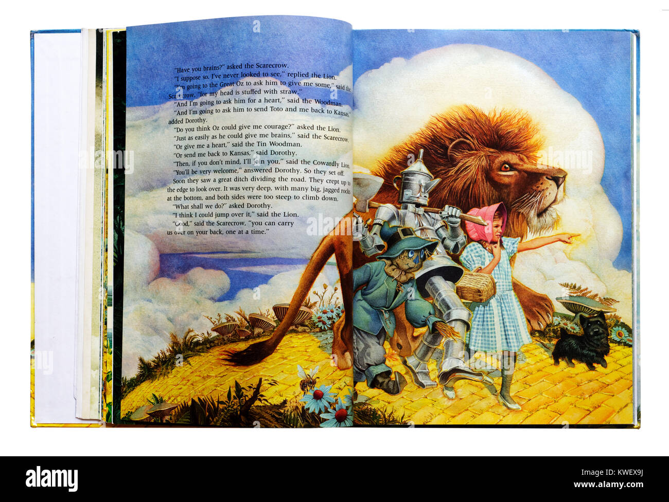 Dorothy, Scarecrow, Tin Woodman and Cowardly Lion on the yellow brick road in an Illustrated book of The Wizard of Oz Stock Photo