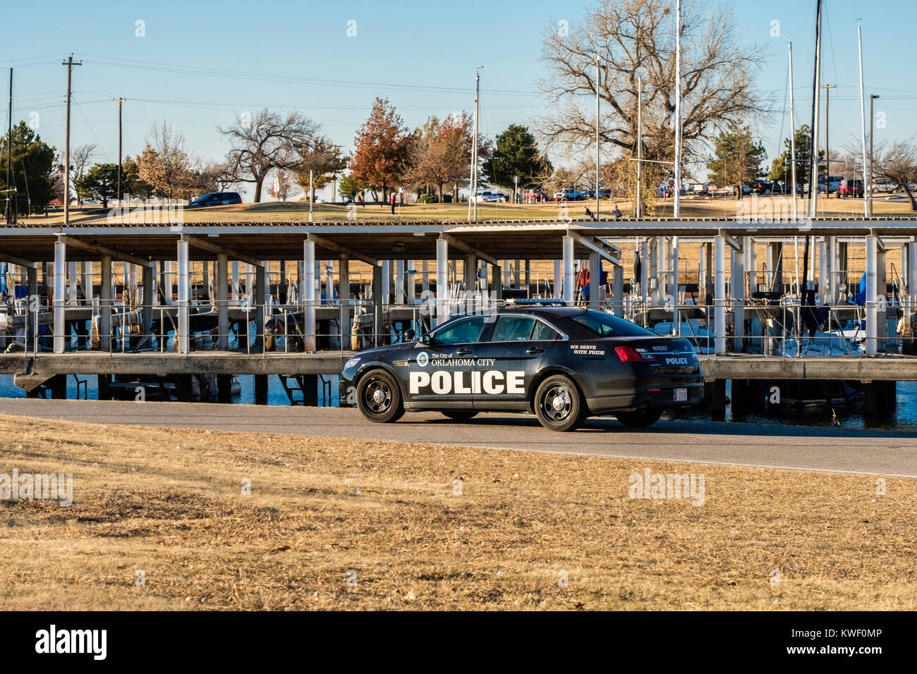 An officer in a police car patrols the marina of Hefner lake in Oklahoma City, Oklahoma, USA. Stock Photo
