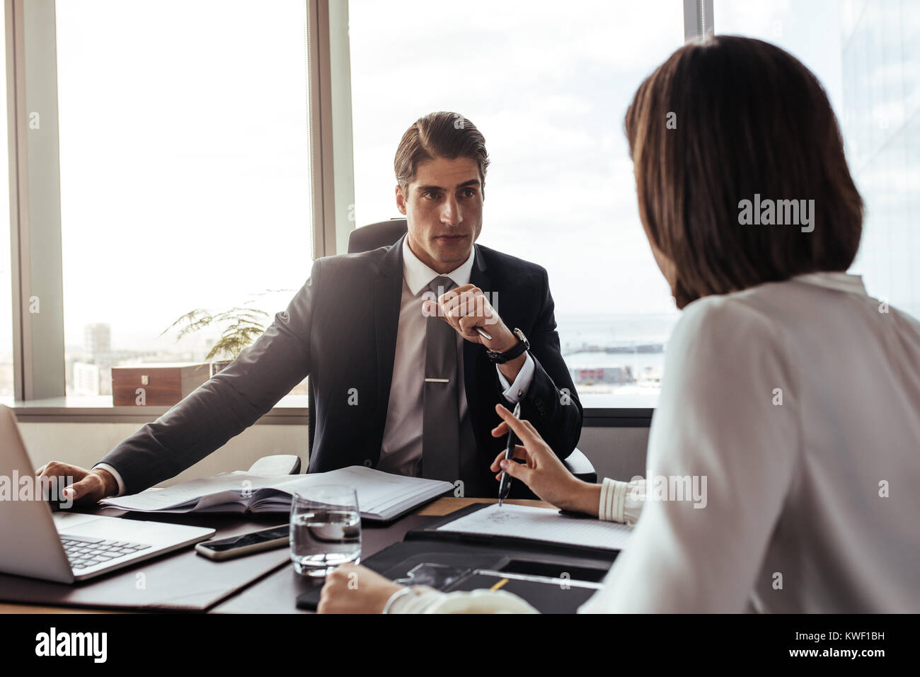 Businessman listening to the suggestions from female colleague. Two corporate professionals having a meeting in office. Stock Photo