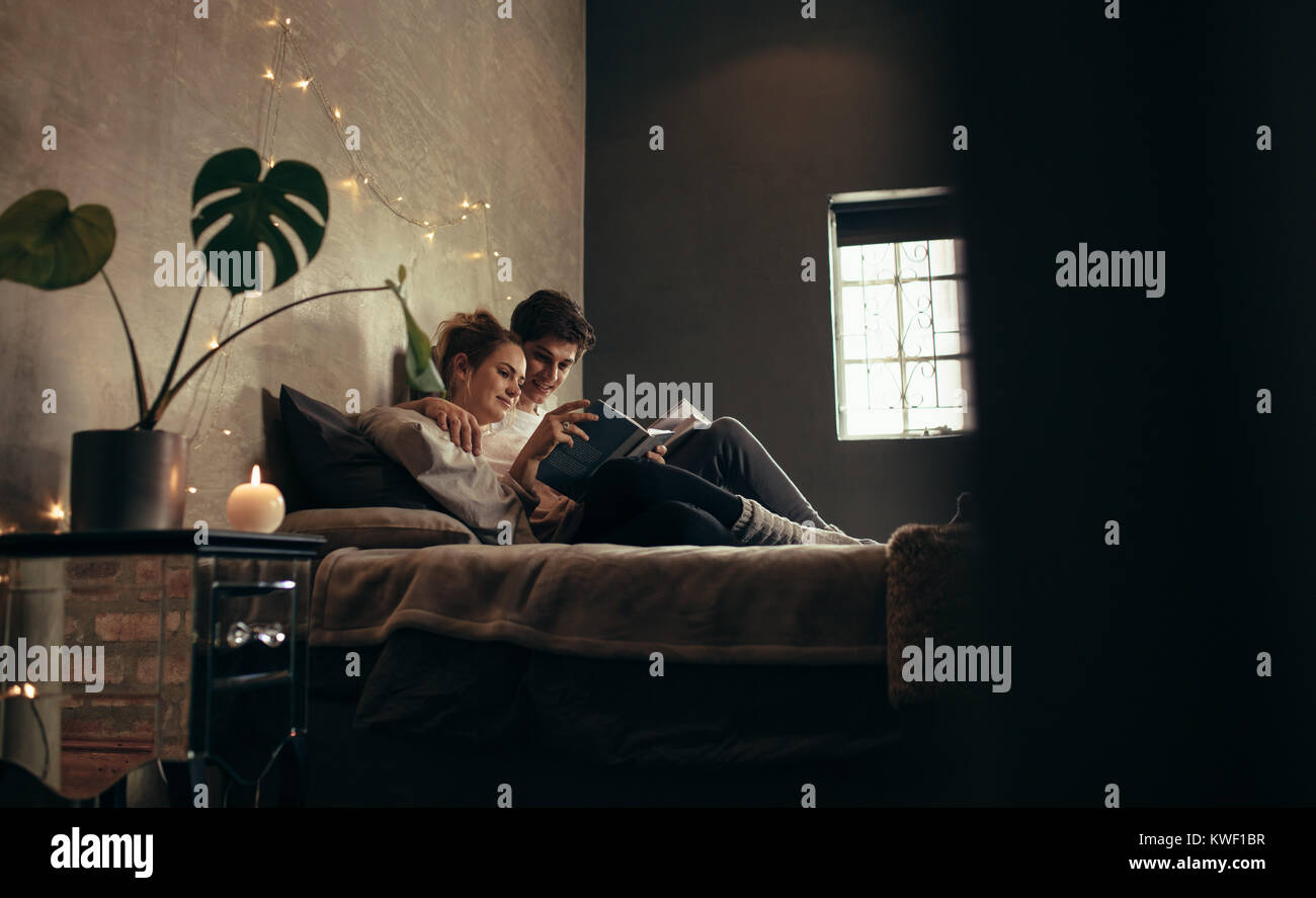 Man And Woman Reading Book Together On The Bed Cozy Couple