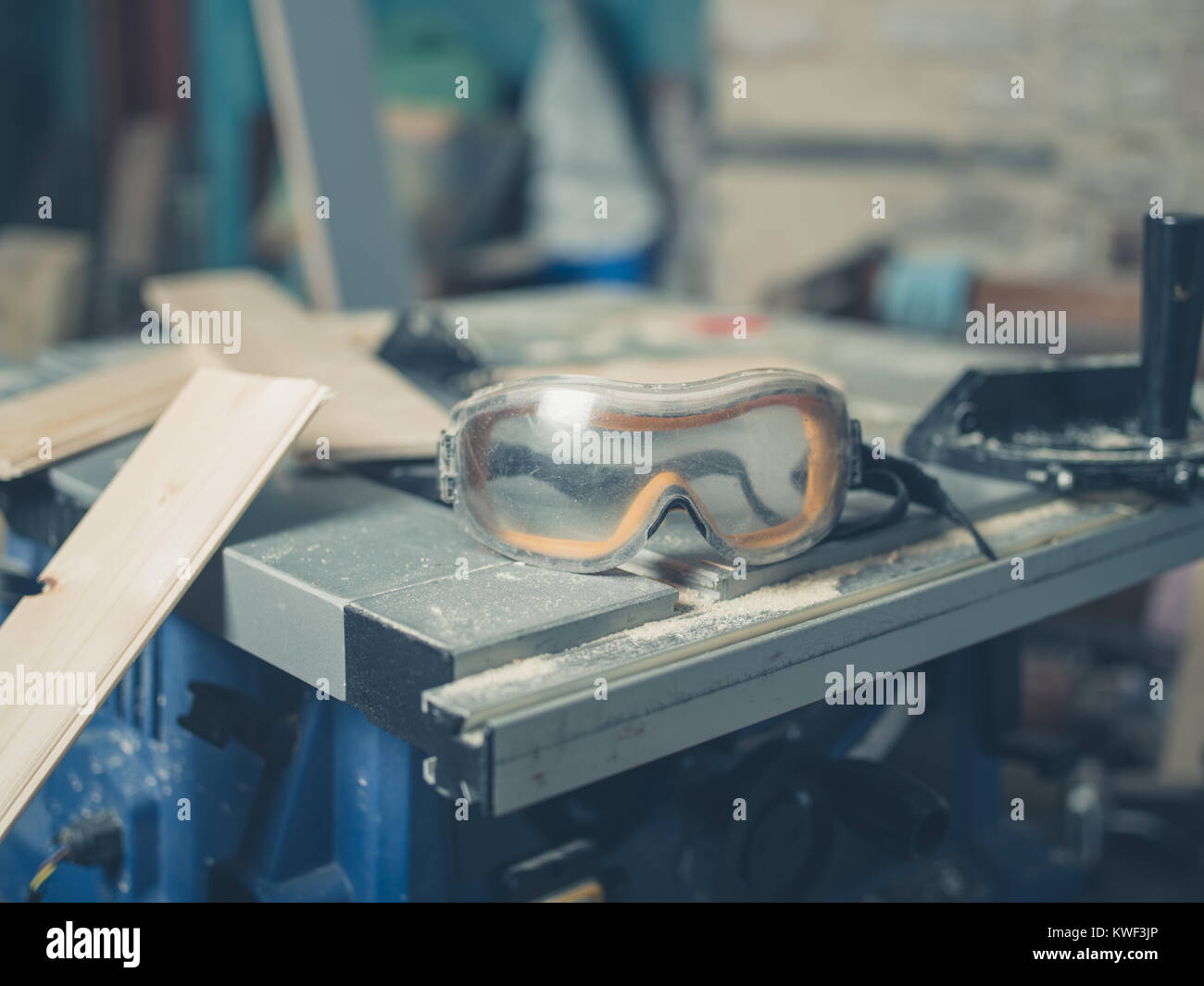 Safety goggles on a table saw with wood Stock Photo
