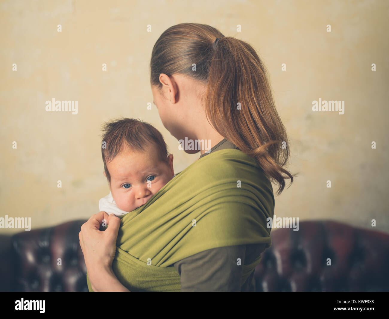 A little baby is being carried in a sling by its mother Stock Photo Alamy