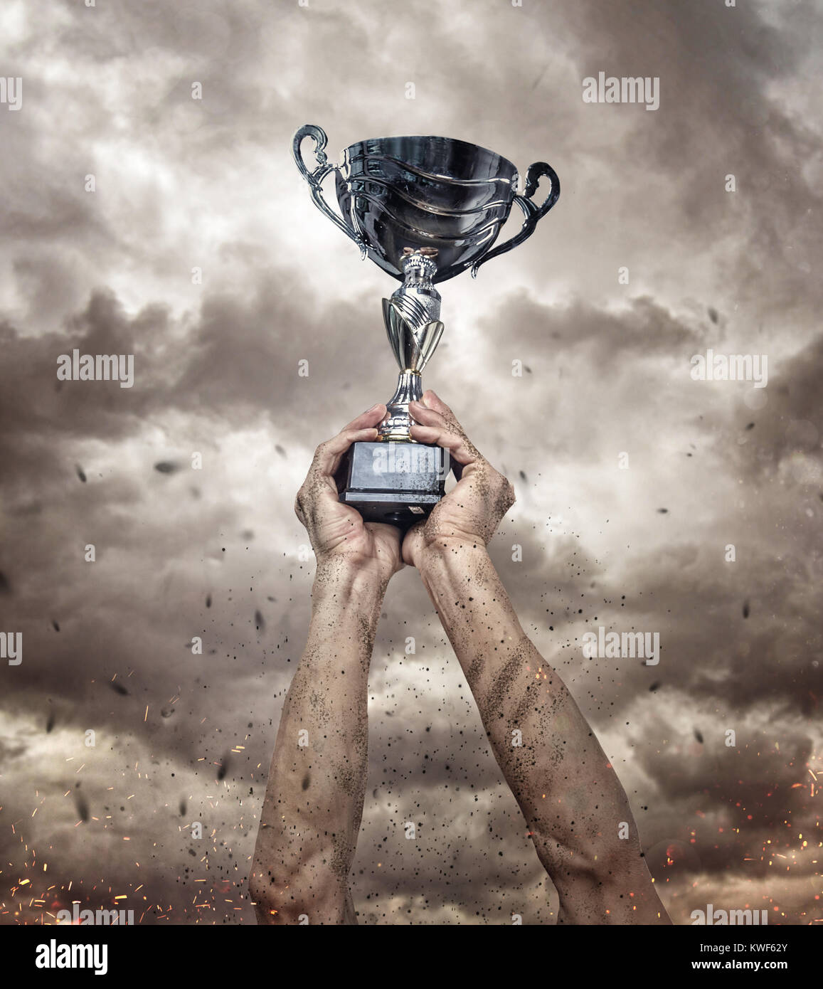 Cropped hand of athlete holding trophy against epic background Stock