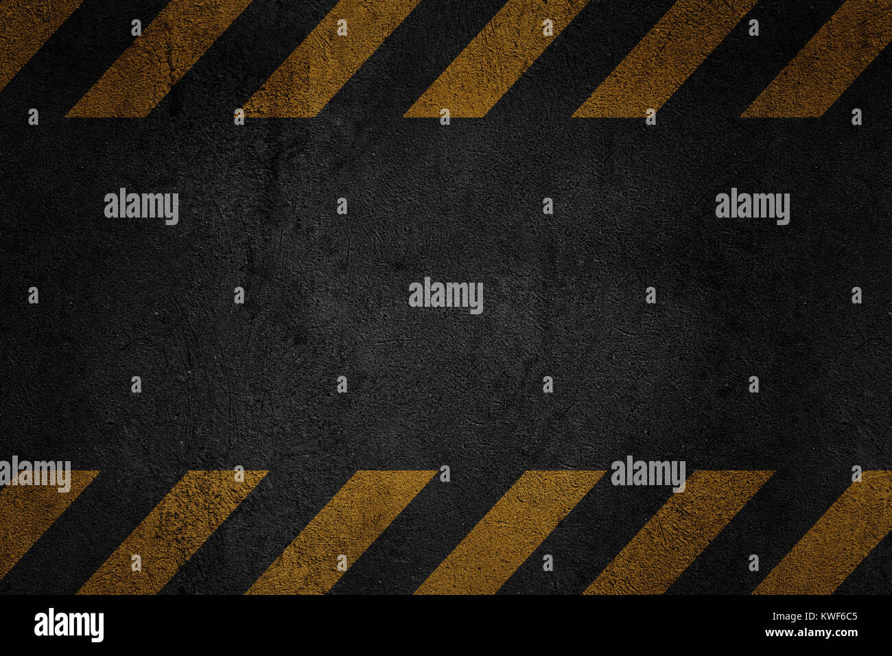Old black grungy metal plate surface with yellow warning stripes. Building, construction. Banner, place for text. Stock Photo