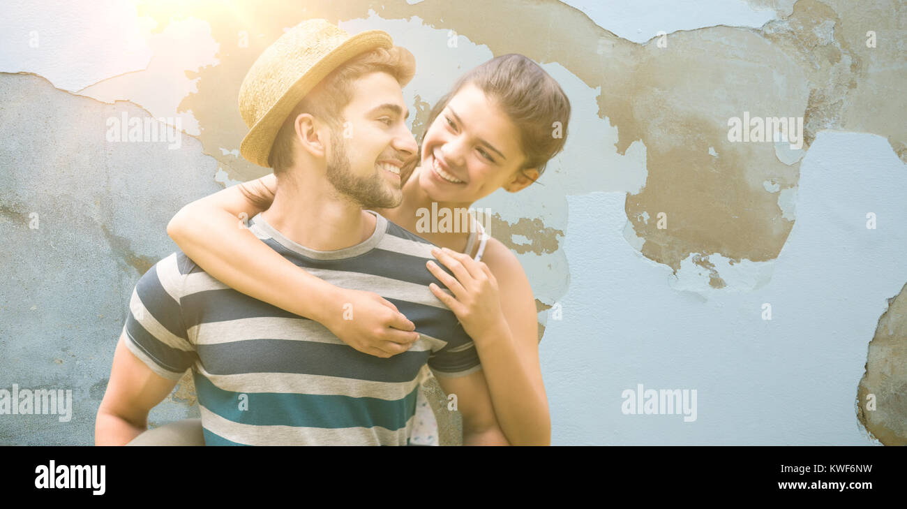 Composite image of man piggybacking woman while smiling Stock Photo