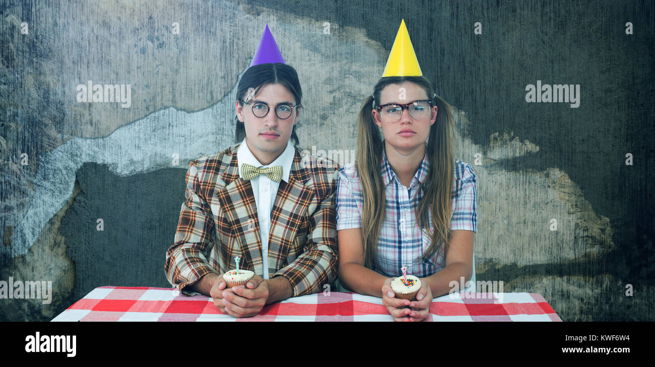 Composite image of unsmiling geeky hipsters celebrating birthday Stock Photo