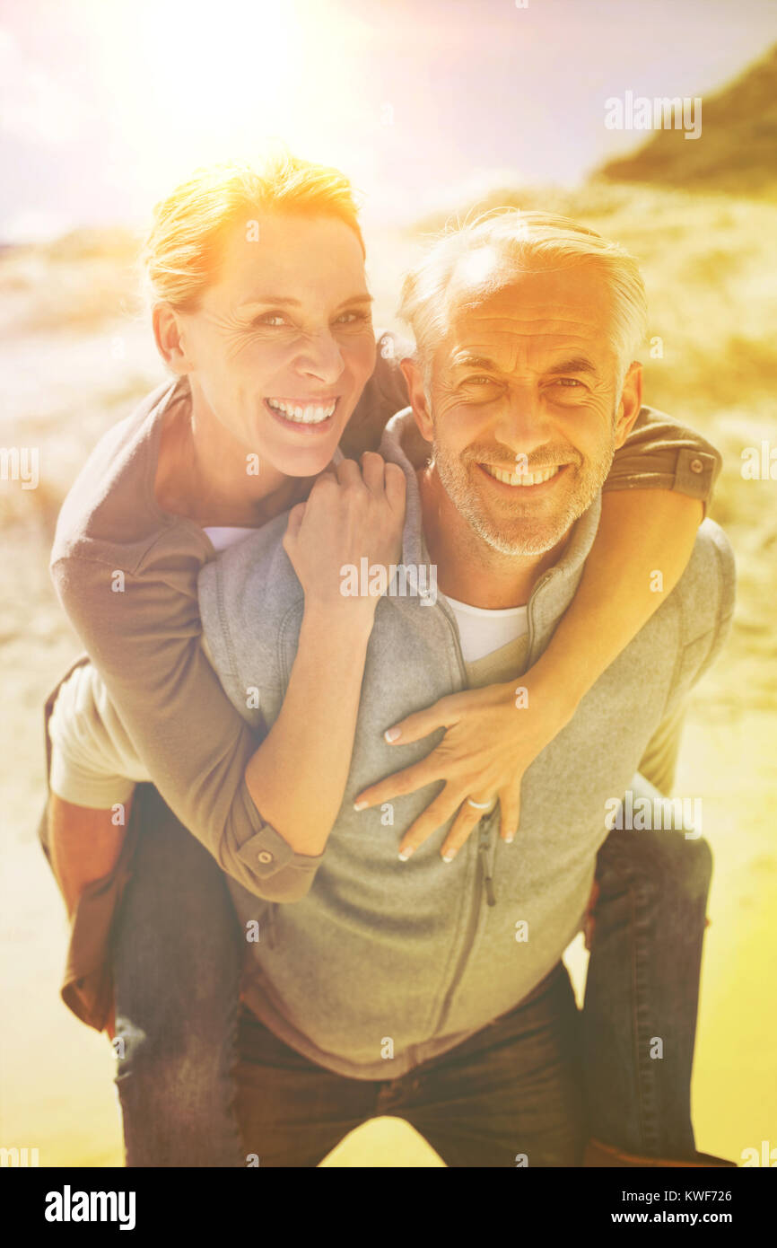 Laughing couple smiling at camera on the beach Stock Photo