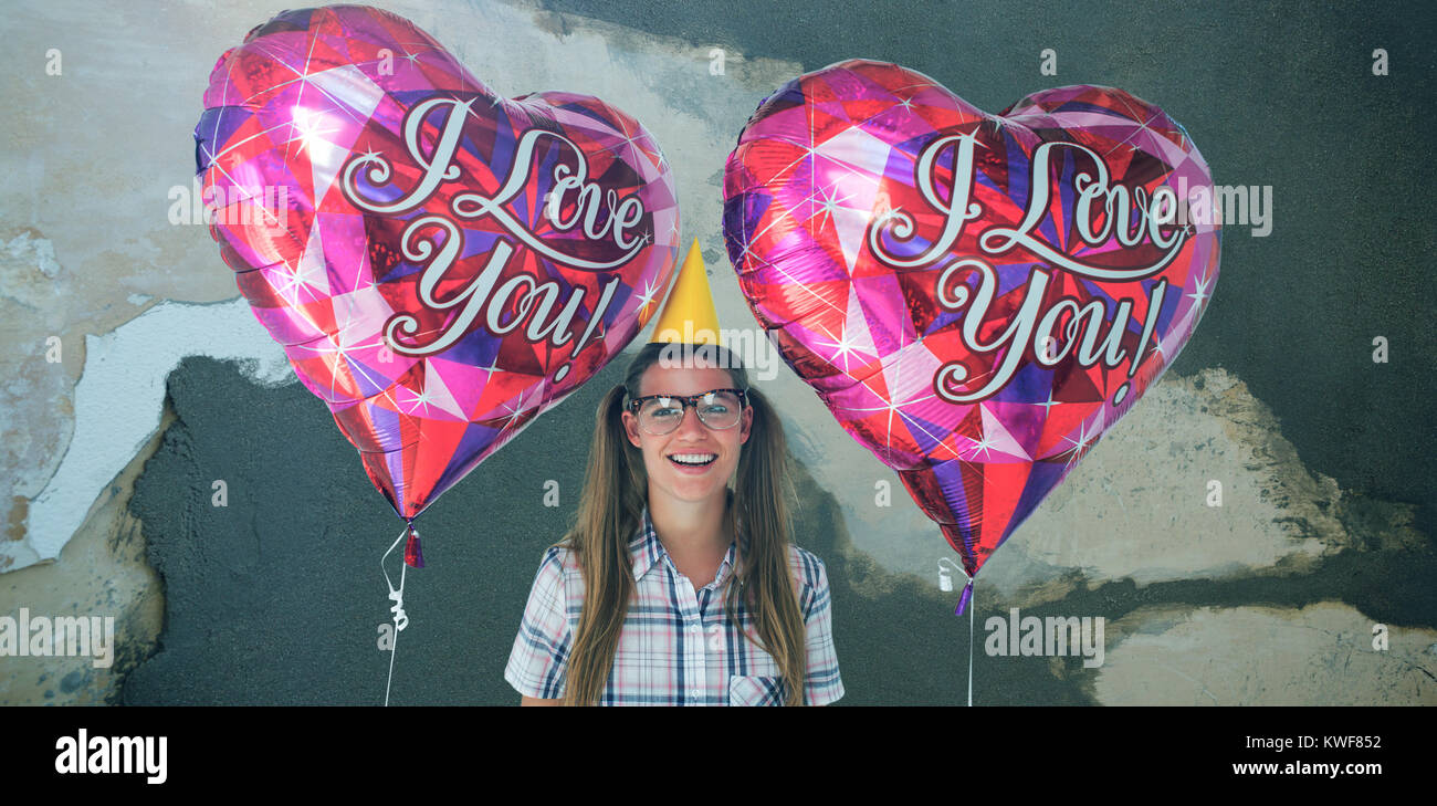 Composite image of geeky hipster holding balloons Stock Photo