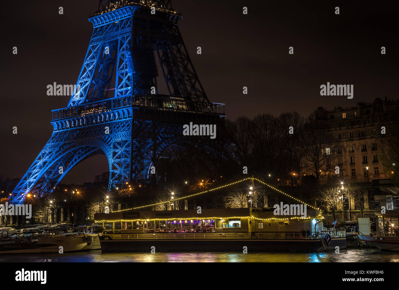Bateau-mouche sur la Seine, vue de la tour Eiffel de nuit dans la belle ville de Paris. Cette nuit la tour Eiffel commémorait le décès de Johnny. Stock Photo