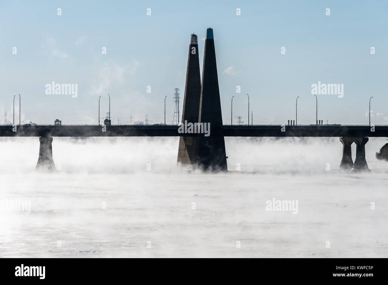 Montreal, CA - 1 January 2018: Pont de la Concorde as ice fog rises off the St. Lawrence River Stock Photo