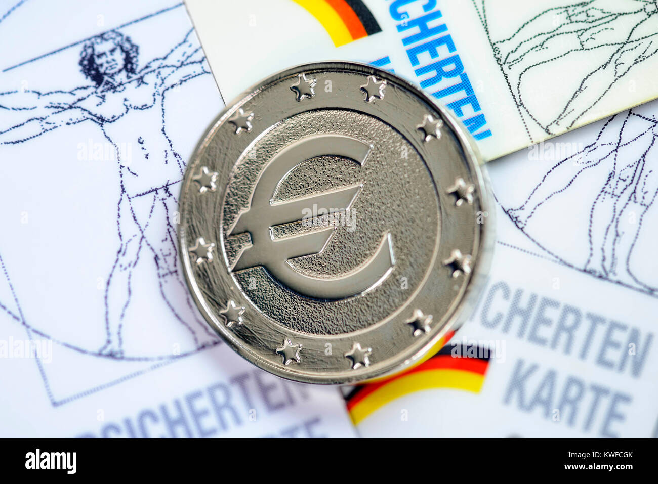 A coin with eurosign on insured person's maps, rise of the health insurance scheme contributions, Eine Muenze mit Eurozeichen auf Versichertenkarten,  Stock Photo