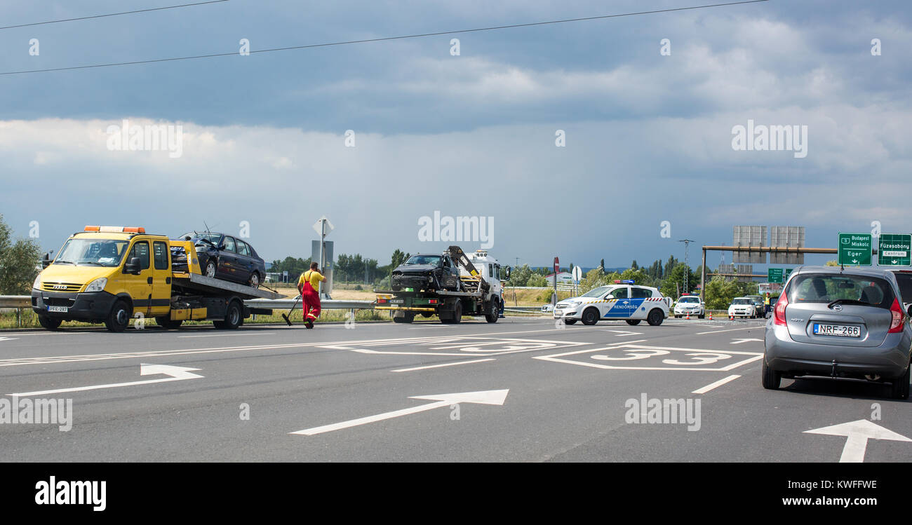 Fuzesabony, Hungary July 15, 2017. Two cars are on the tow trucks after the accident on the road. Police blocked traffic. On the road broken glass Stock Photo