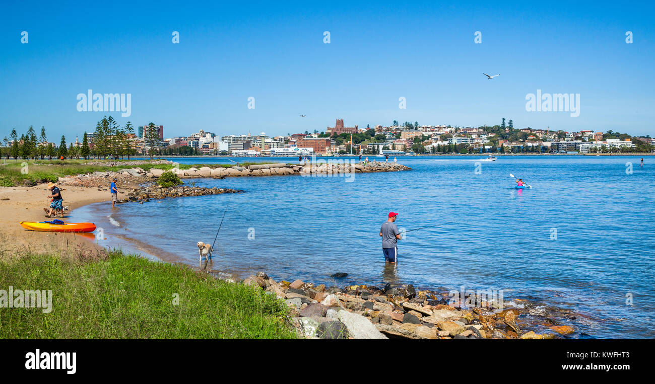 Australia, New South Wales, Hunter Region, fising on the banks of the Hunter River at Stockton with view of Newcastle across the Hunter River Stock Photo