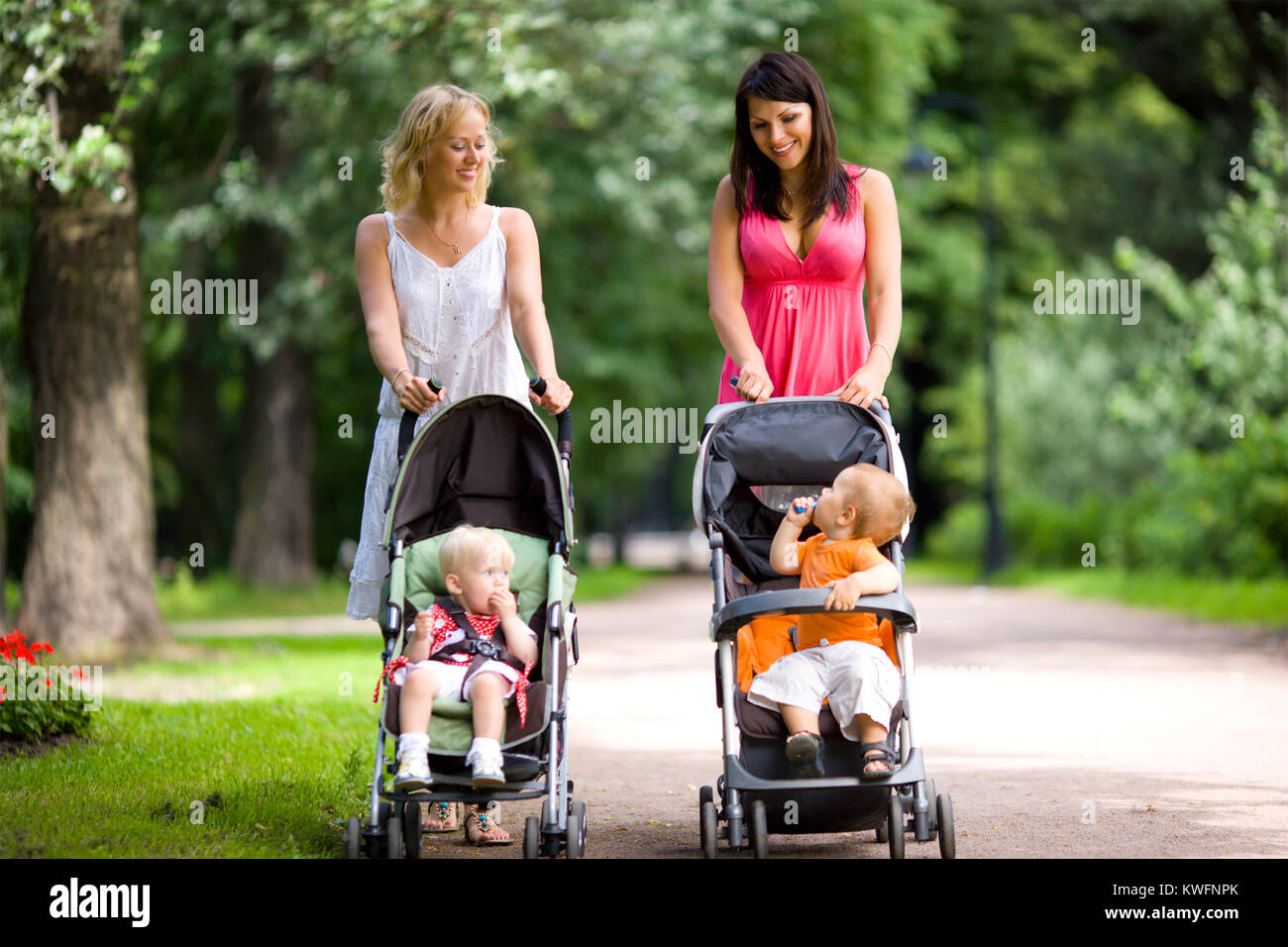 Happy mothers walking together with kids in prams Stock Photo Alamy