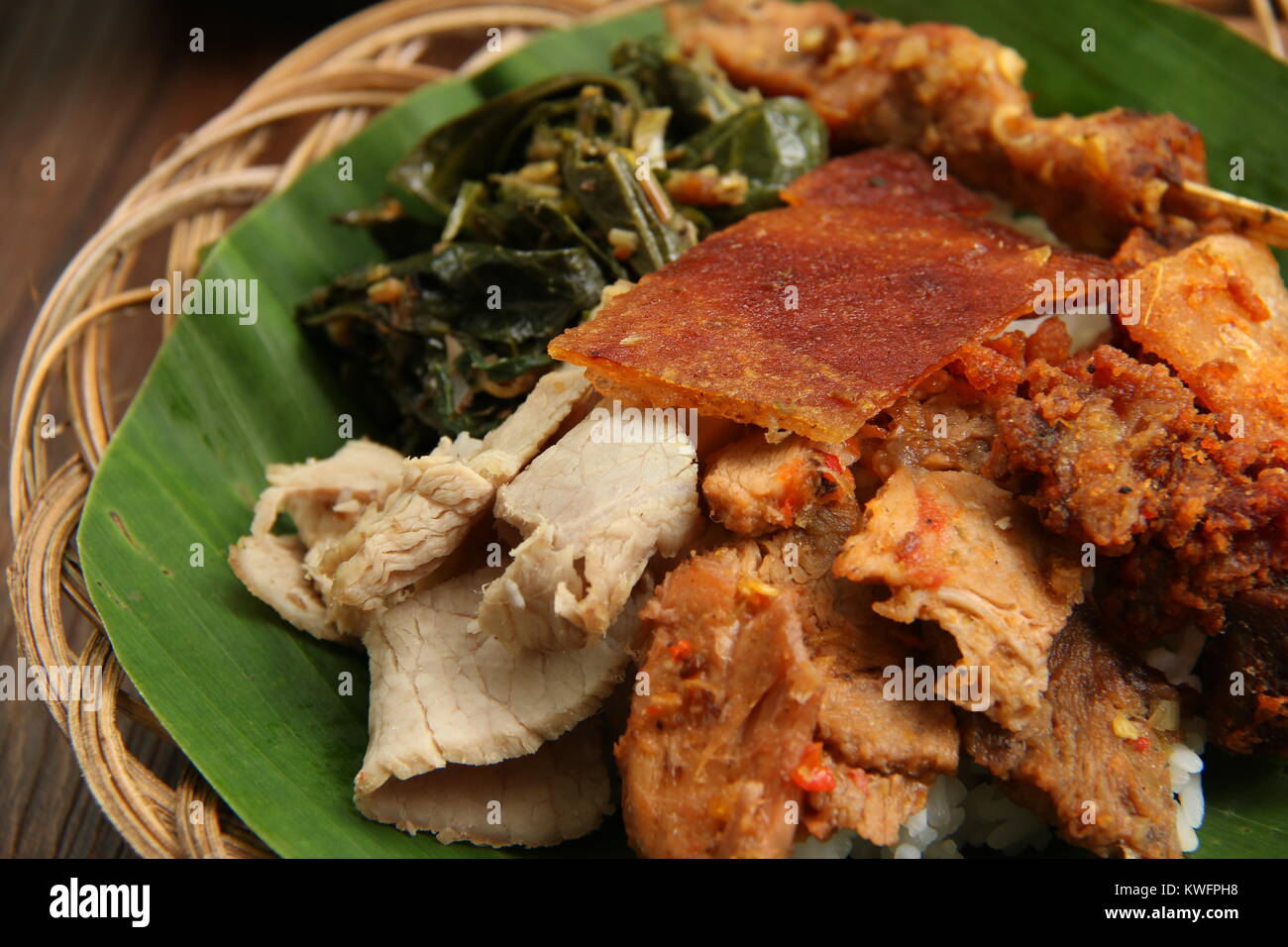 Nasi Campur Babi Guling. Balinese rice dish of steamed rice topped with  variety of roast pork dishes Stock Photo - Alamy