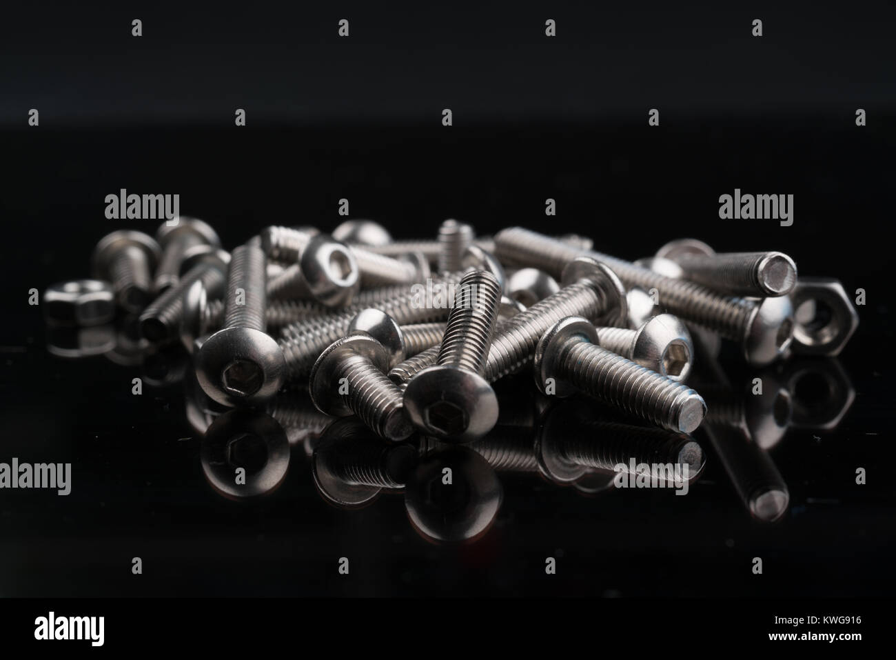 metal fasteners screws and nuts on black background. screw isolated on