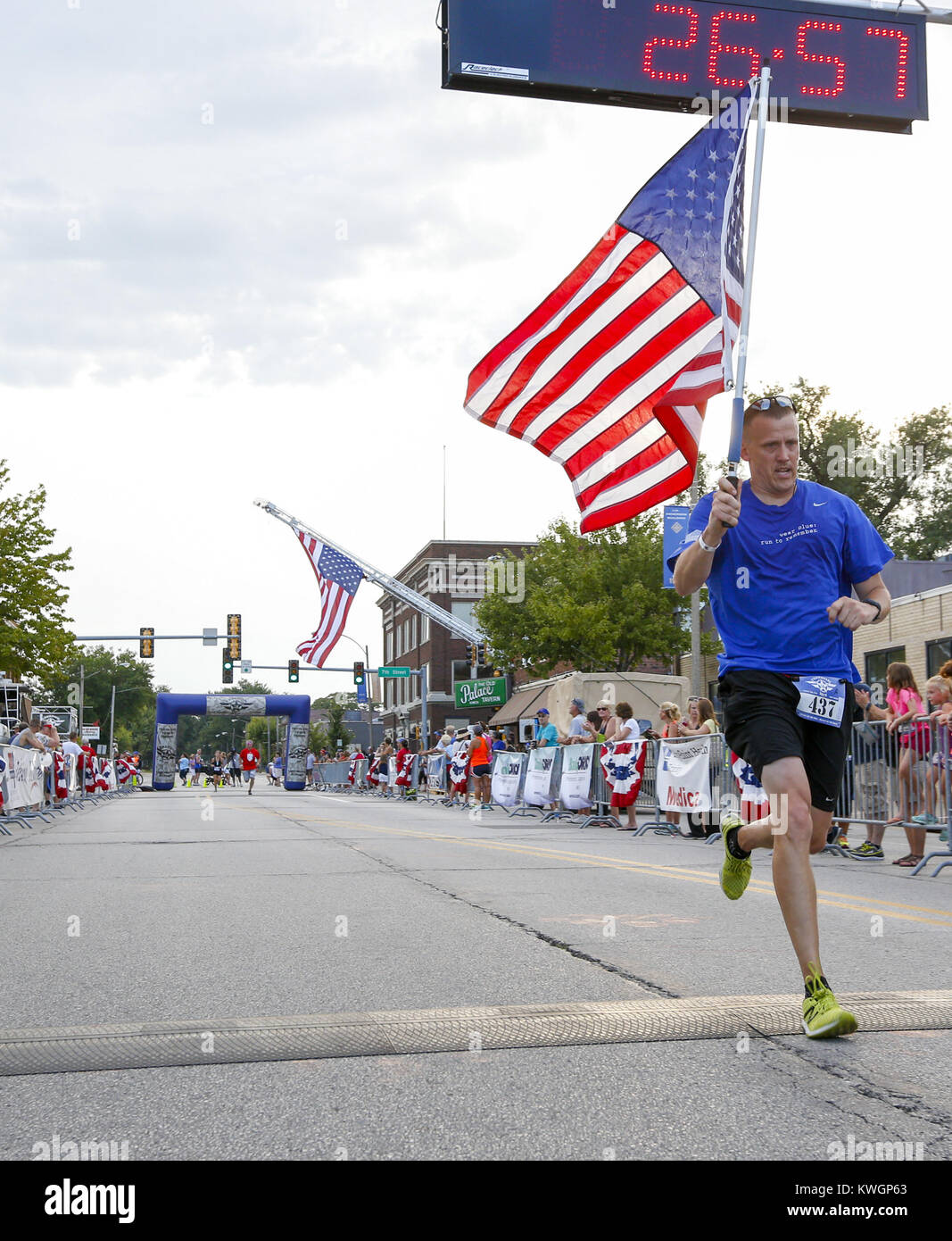 Davenport, Iowa, USA. 4th Aug, 2016. Shawn Muder of Davenport crosses the line of the 5k Freedom Run with an American flag in hand in East Moline on Thursday, August 4, 2016. The Freedom Run 5k, which featured a kid's obstacle and one mile race as well as the 5k itself, was held in downtown East Moline as a benefit to local military families. Credit: Andy Abeyta/Quad-City Times/ZUMA Wire/Alamy Live News Stock Photo