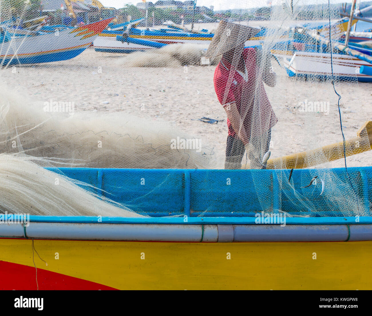 Fisherman cleaning nets over a traditional fishing vessel Stock Photo Alamy