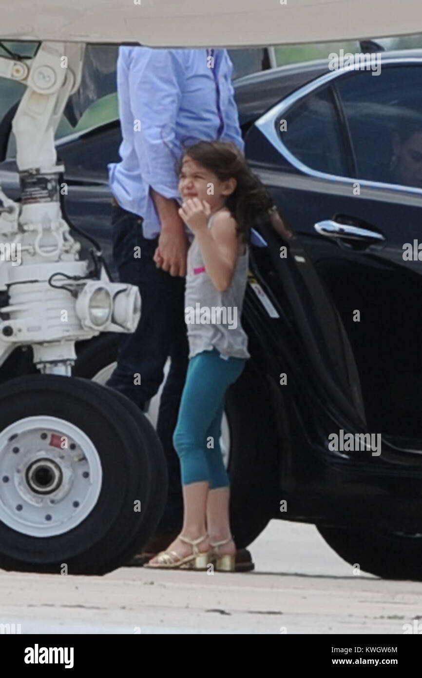 MIAMI, FL - MAY 17:  Suri Cruise seems to be a fashion diva wearing her high heels as she boards her private Gulfstream Jet. Dad Tom Cruise, and mom Katie Holmes accompanied Suri on her flight.  on May 17, 2011 in Miami , Florida   People:  Tom Cruise_Suri Cruise_Katie Holmes Stock Photo