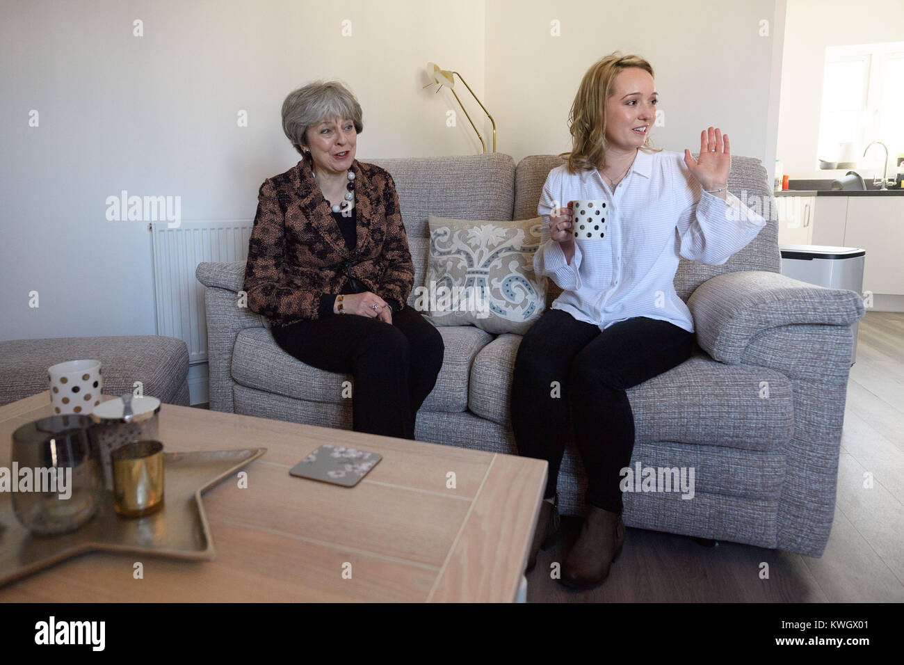Prime Minister Theresa May (left) chats with first-time buyer Laura Paine during a visit to new housing development Montague Park in Wokingham, Berkshire. Stock Photo