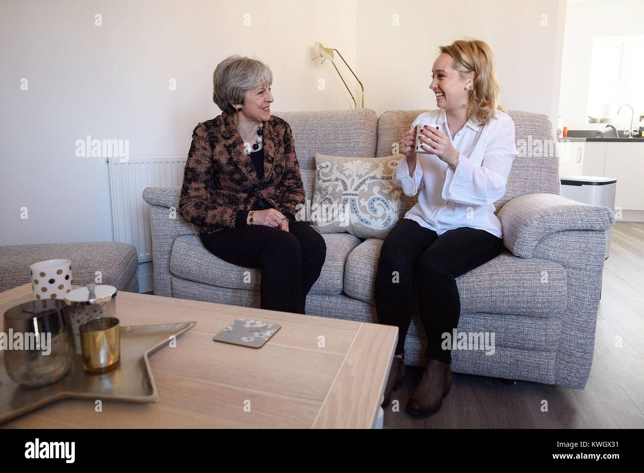 Prime Minister Theresa May (left) chats with first-time buyer Laura Paine during a visit to new housing development Montague Park in Wokingham, Berkshire. Stock Photo
