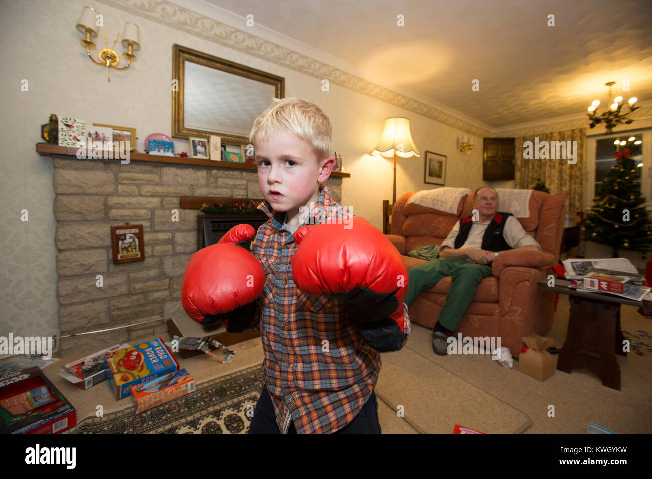 A Grandfather gives his young grandsons a boxing lesson inside the lounge of their residential home in the United Kingdom Stock Photo