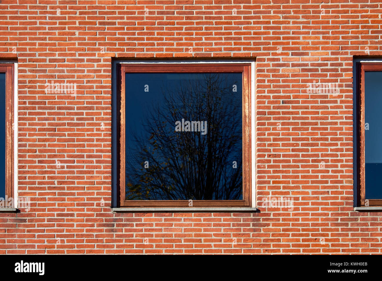 Square window with hardwood frame in a red brick facade Stock Photo