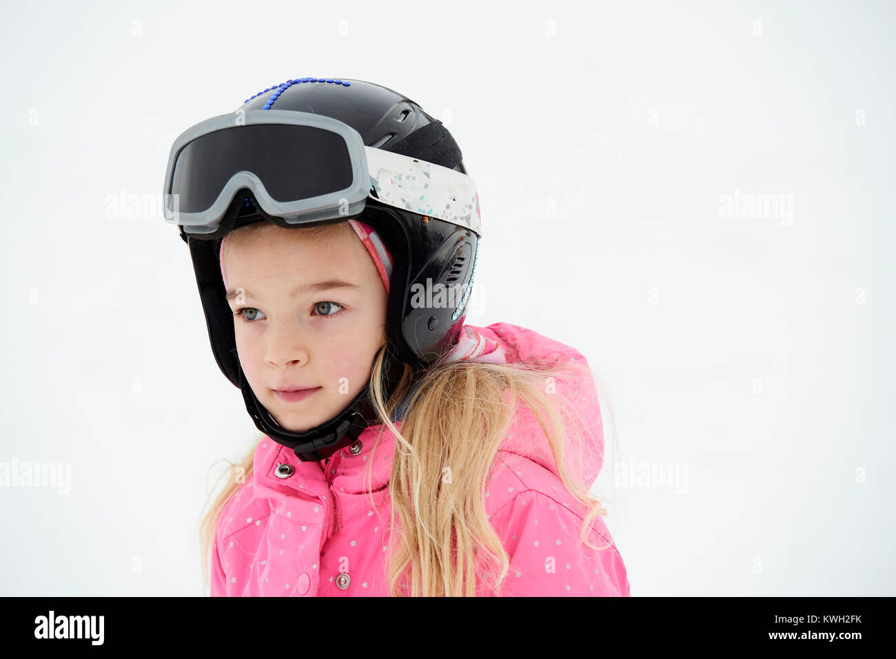 Cute adorable preschooler caucasian kid girl portrait with ski in helmet,  goggles and unicorn fun costume enjoy winter sport activities. Little child  skiing on luxury alpine resort in mountains, Stock image