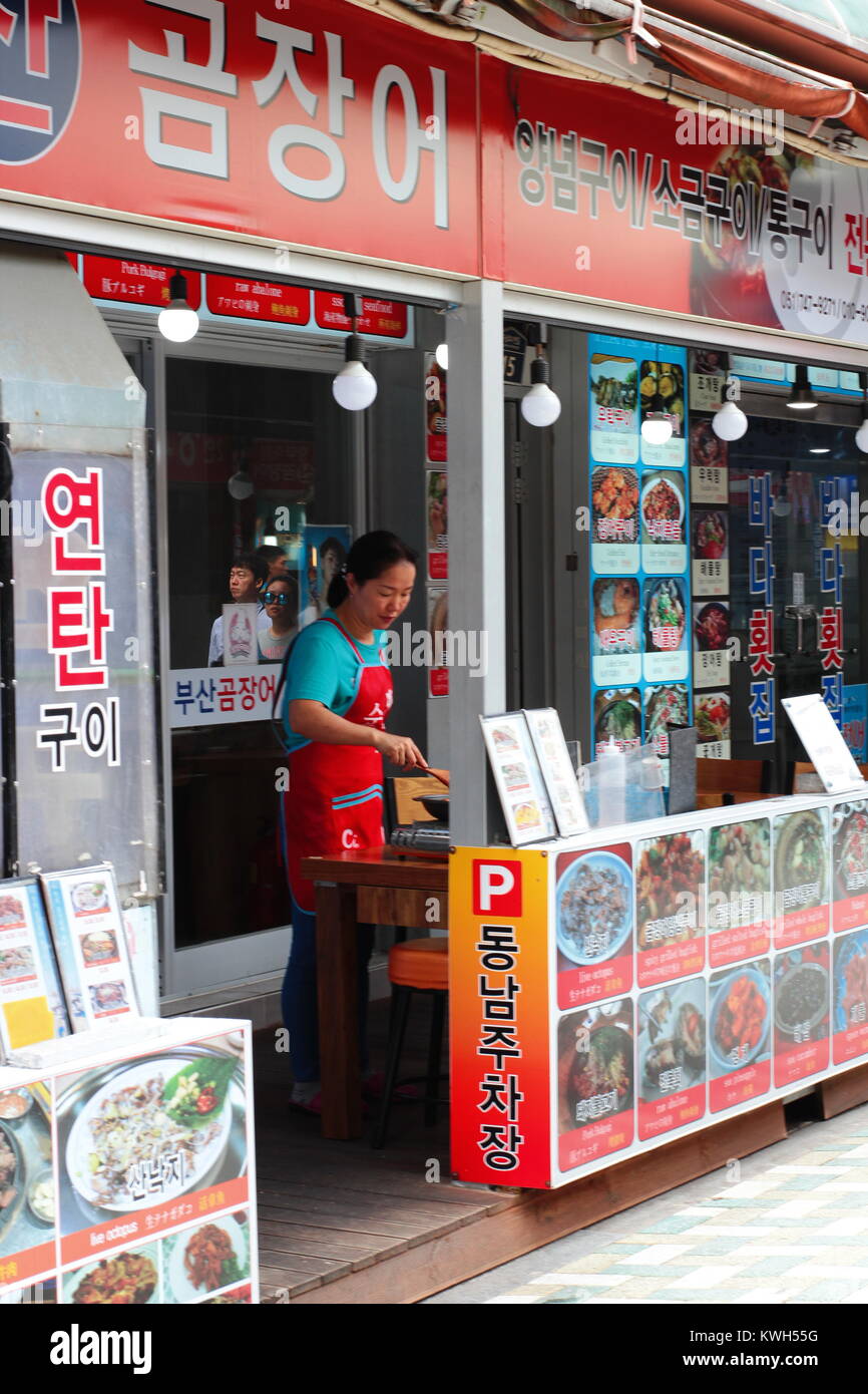 A woman preparing food at Korean street food stall in traditional