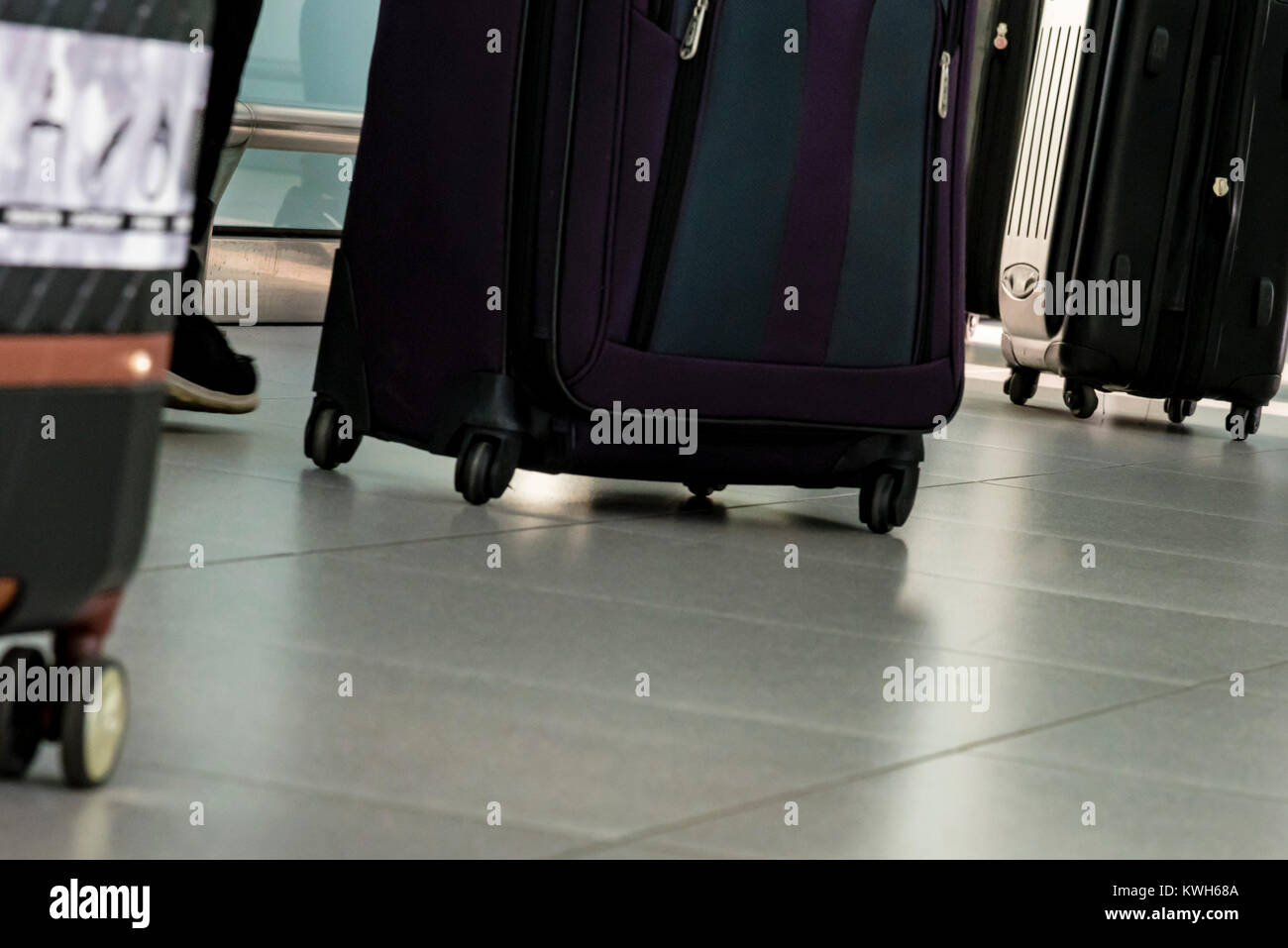 Travelers at airport carry bags. Travel concept. People hurry with luggage at airport terminal. Stock Photo