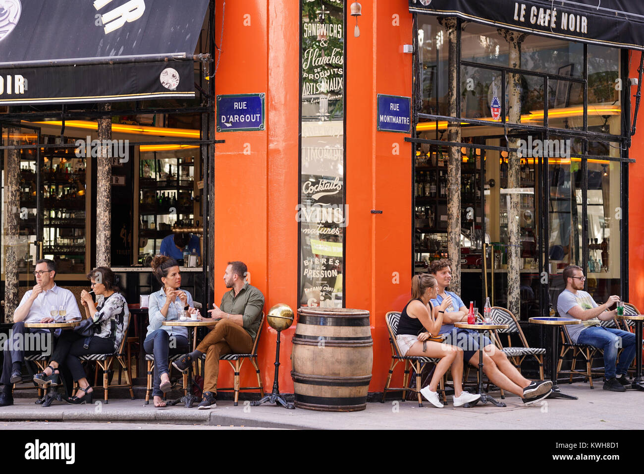 Paris cafe - People sitting outside the Parisian Le Cafe Noir in the 2nd arrondissement of Paris, France, Europe. Stock Photo