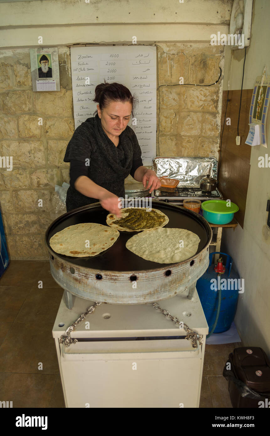 Deir el Qamar, Lebanon, April 05 - 2017: Lebanese woman preparing a typical Lebanese food, preparing the Zaatar Manoucher. Stock Photo