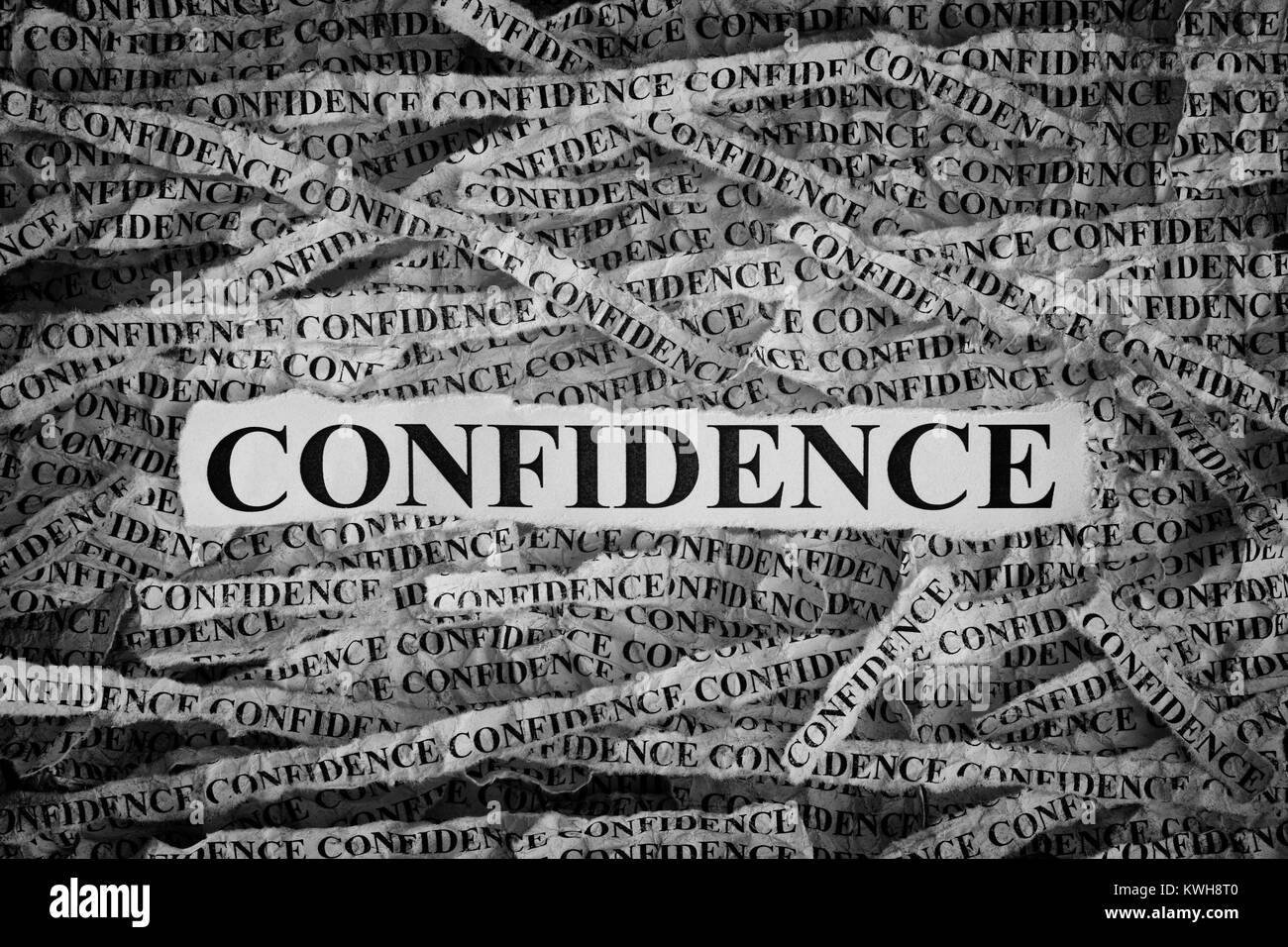 Confidence. Torn pieces of paper with word Confidence. Concept Image. Black and White. Closeup. Stock Photo
