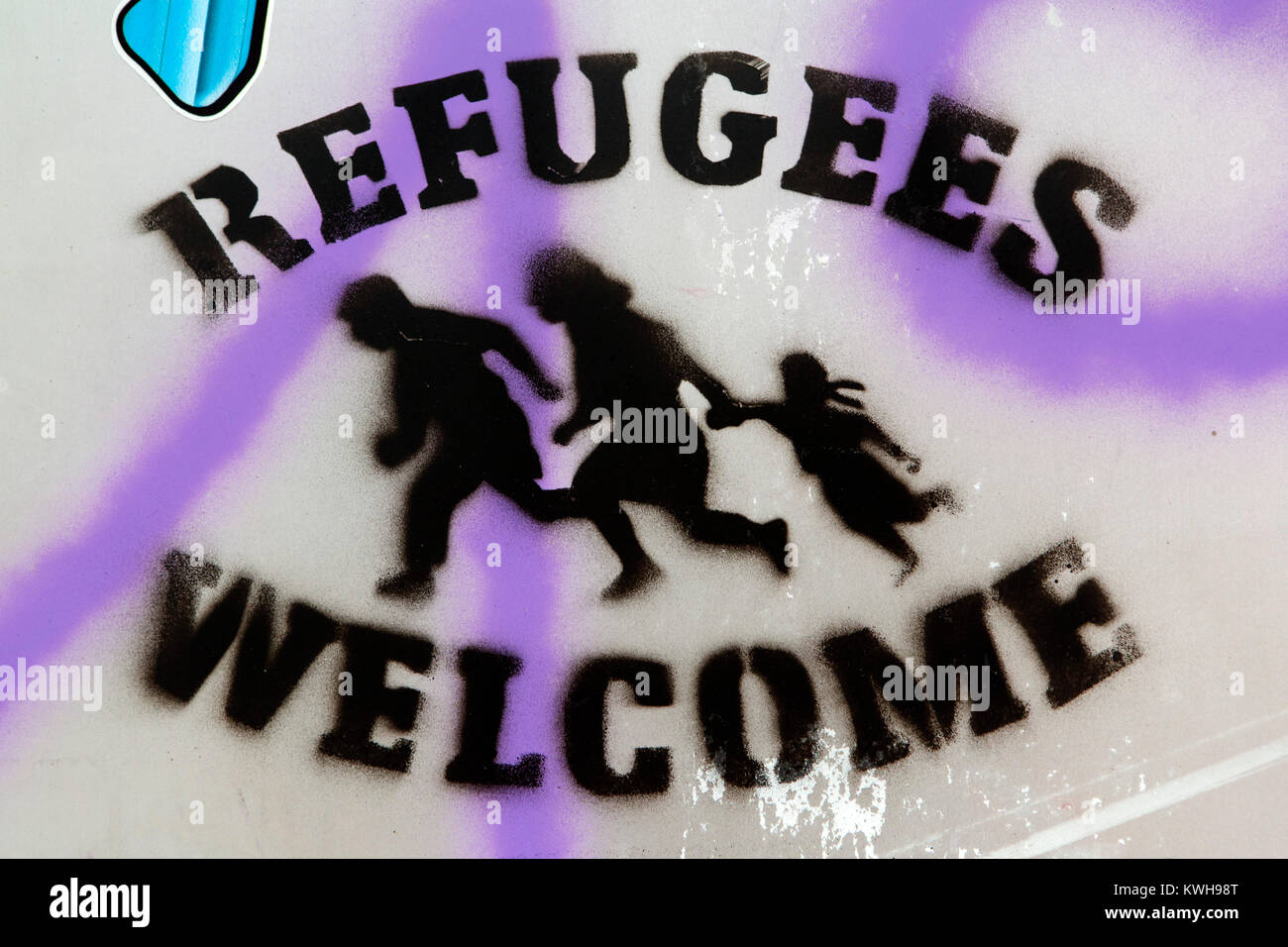 Stencilled graffiti says ' Refugees Welcome' in Maribor, Slovenia. The graffiti is on a city centre wall. Stock Photo