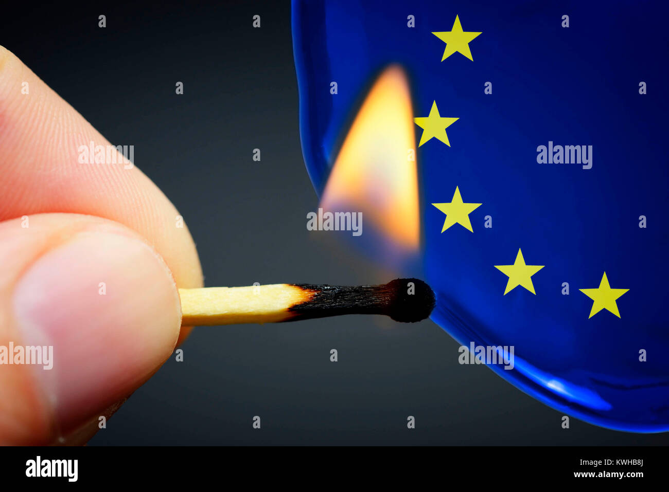 Finger with burning match before liquid with EU stars, symbolic photo chain reaction to Grexit, Finger mit brennendem Streichholz vor FlÃ¼ssigkeit mit Stock Photo