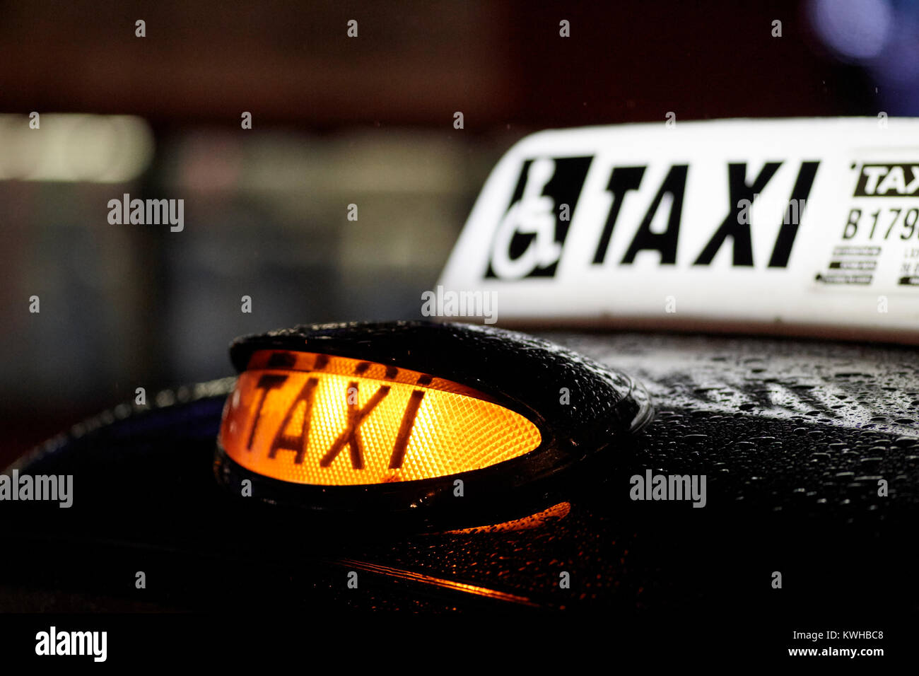 yellow taxi rooftop for hire light at night in the rain belfast northern ireland uk Stock Photo