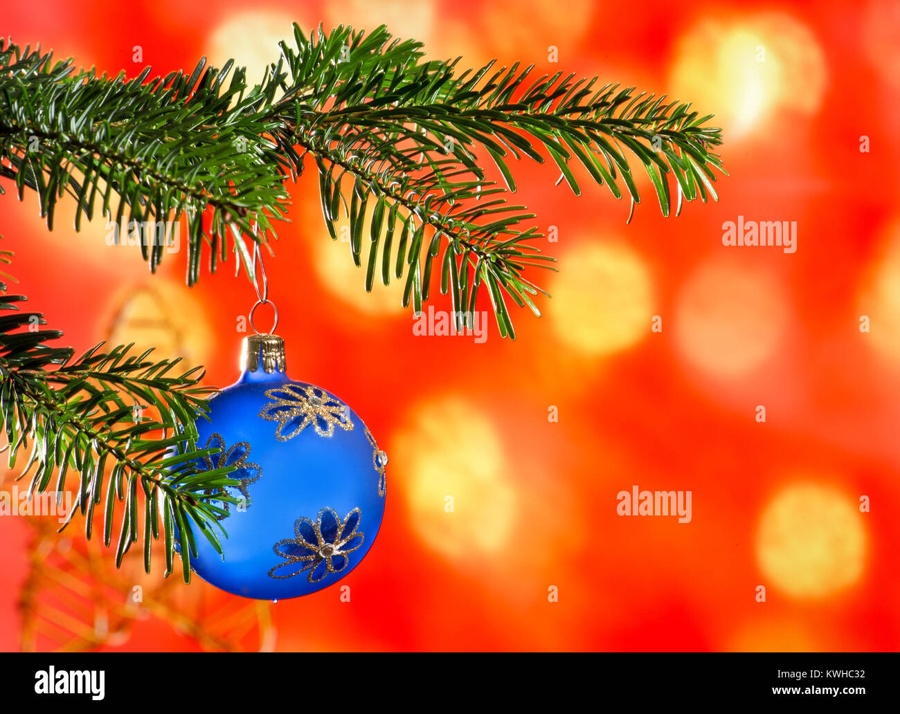 Blue Christmas Ball with Christmas Twig on the Red Background. Stock Photo