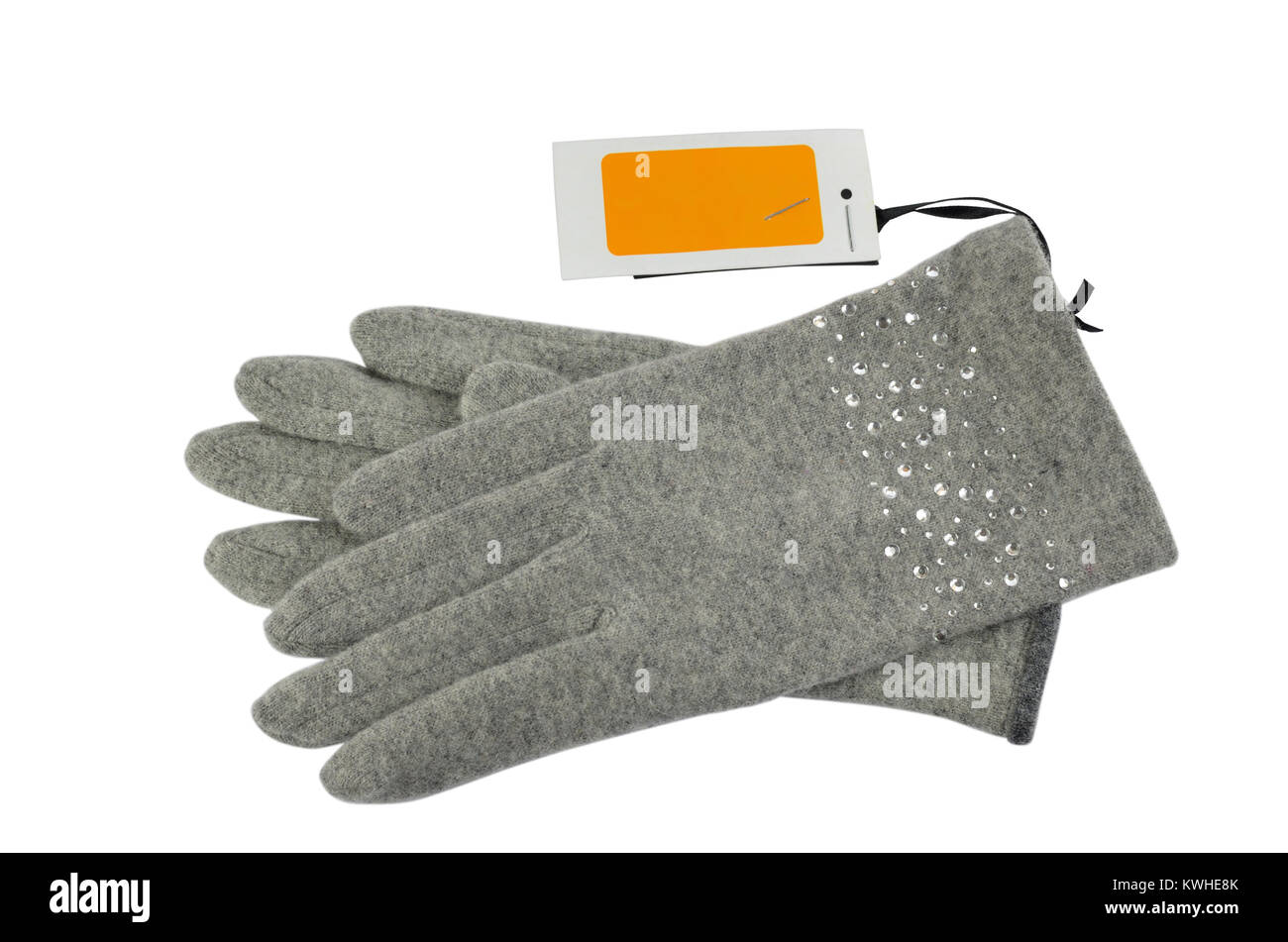 Pair of grey woolen gloves with a blank white-orange price tag beside it, on white background Stock Photo