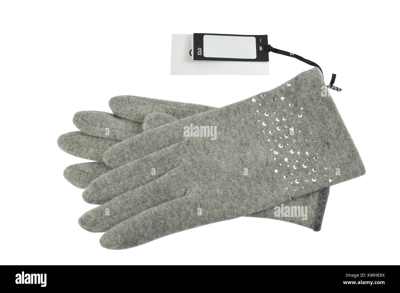 Pair of grey woolen gloves with a blank price tag beside it, on white background Stock Photo