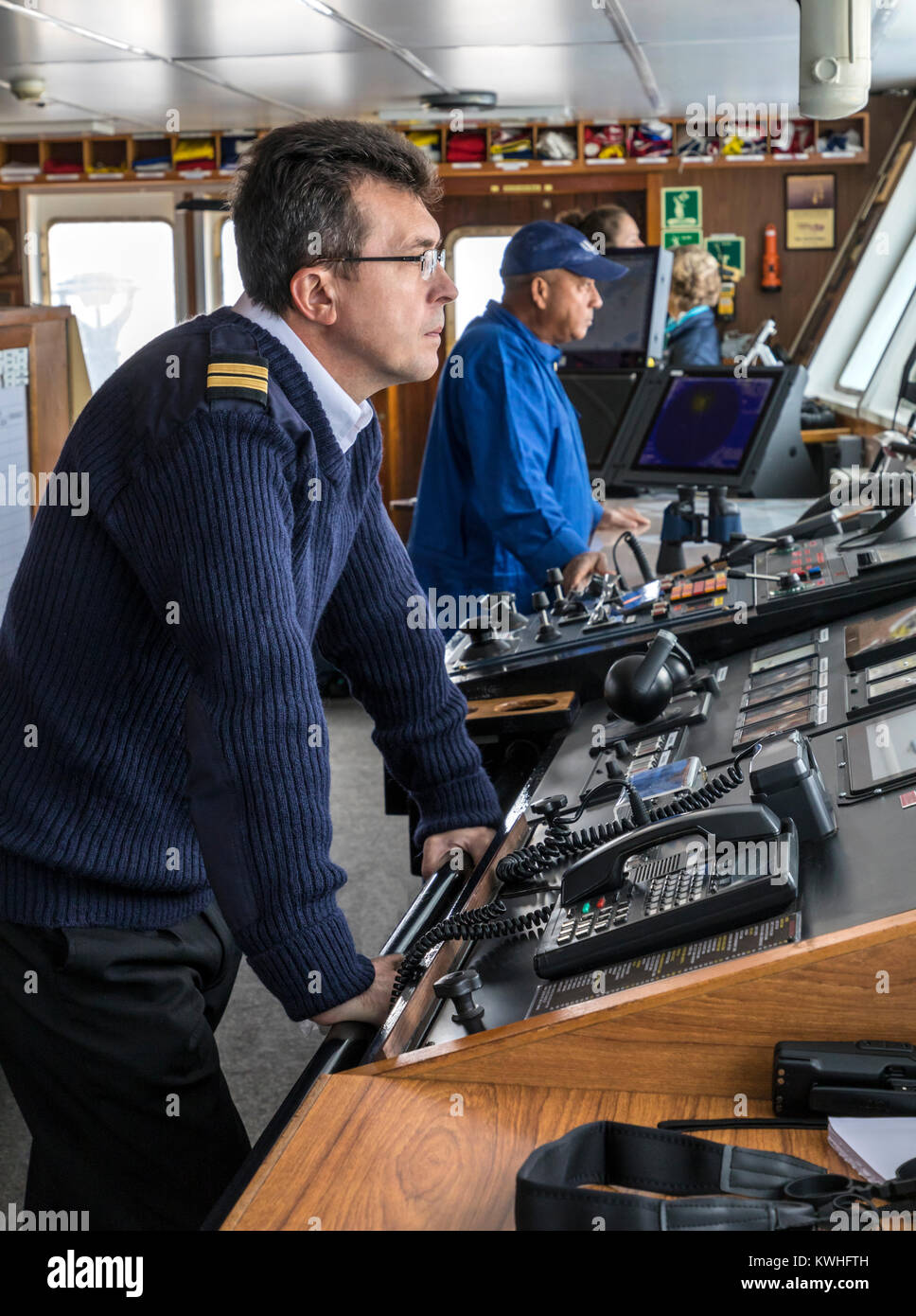 Ship's crew on bridge sailing passenger ship Ocean Adventurer; carries alpine mountaineering skiers to Antarctica Stock Photo