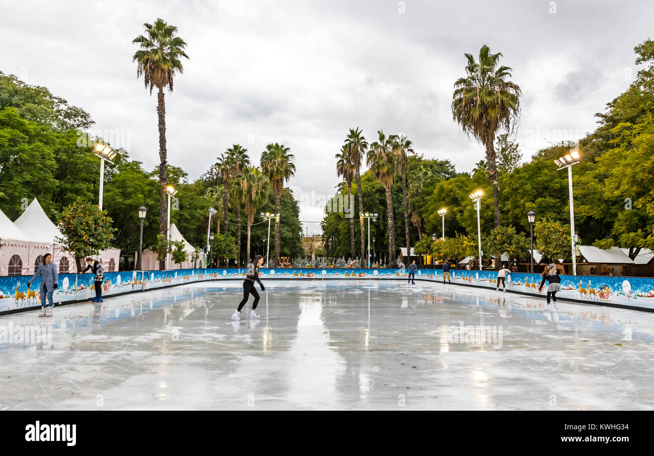 Ice skaters having fun on skating rink at traditional Christmas fair on