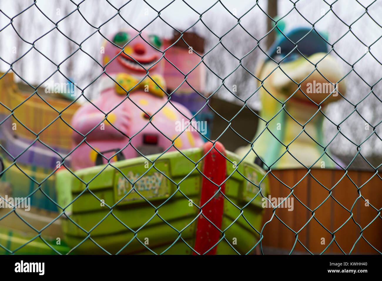 Mr Blobby amusement ride through a wire fence in a secondhand yard, Margate Stock Photo
