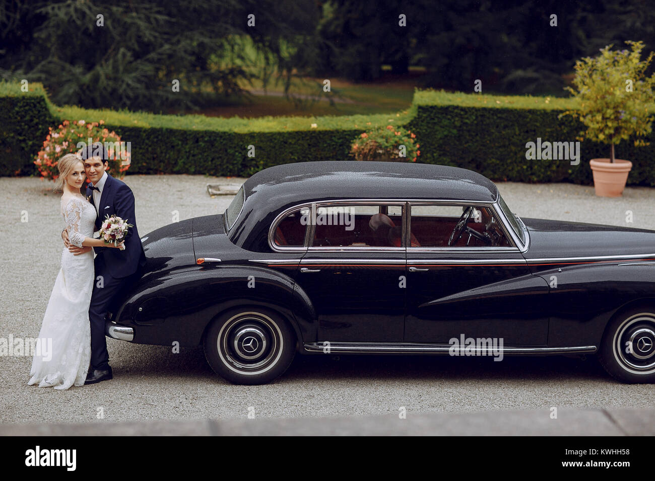 bride and groom standing in the yard near the car Stock Photo - Alamy