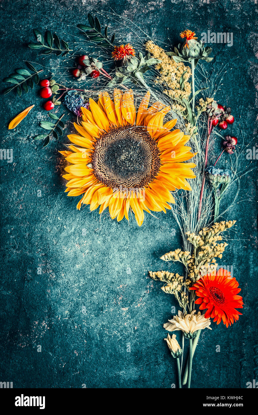 Autumn flowers arrangements with sunflowers, leaves and canina berries