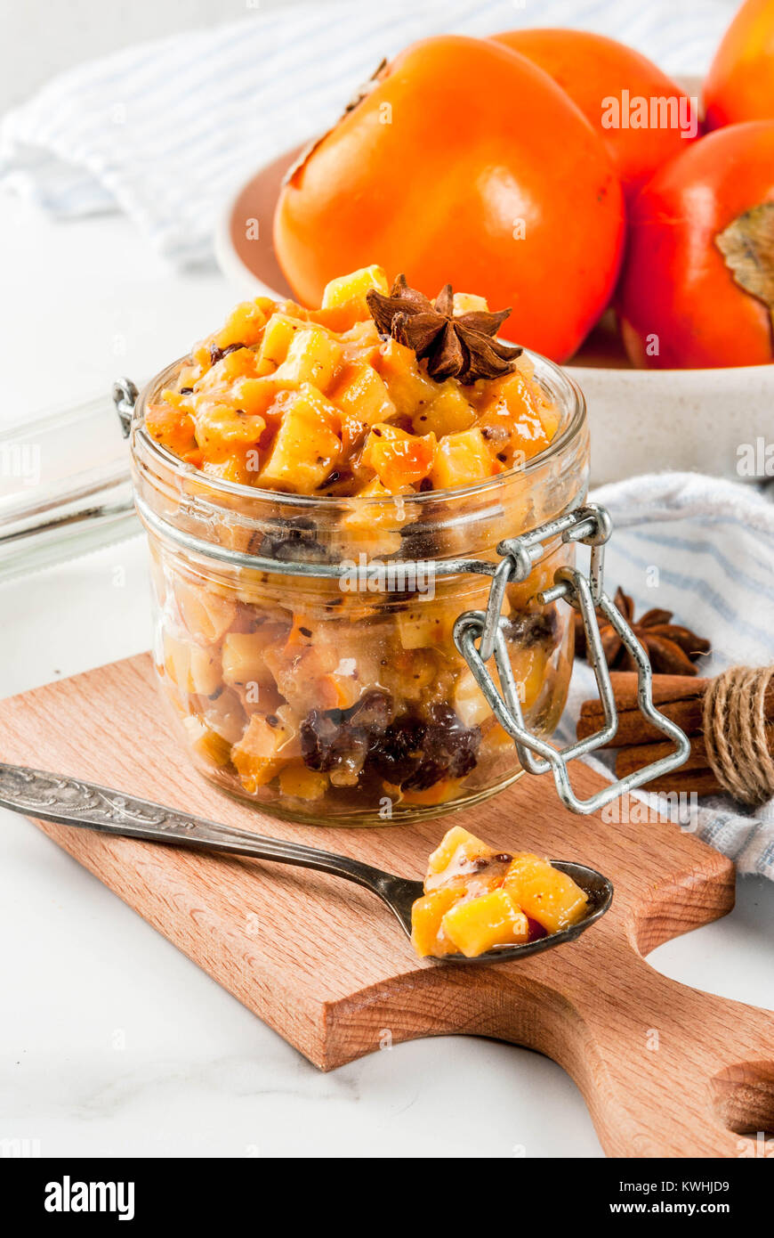 Traditional indian food recipes, Persimmon fruit Chutney with cinnamon and anise stars, white marble background copy space Stock Photo