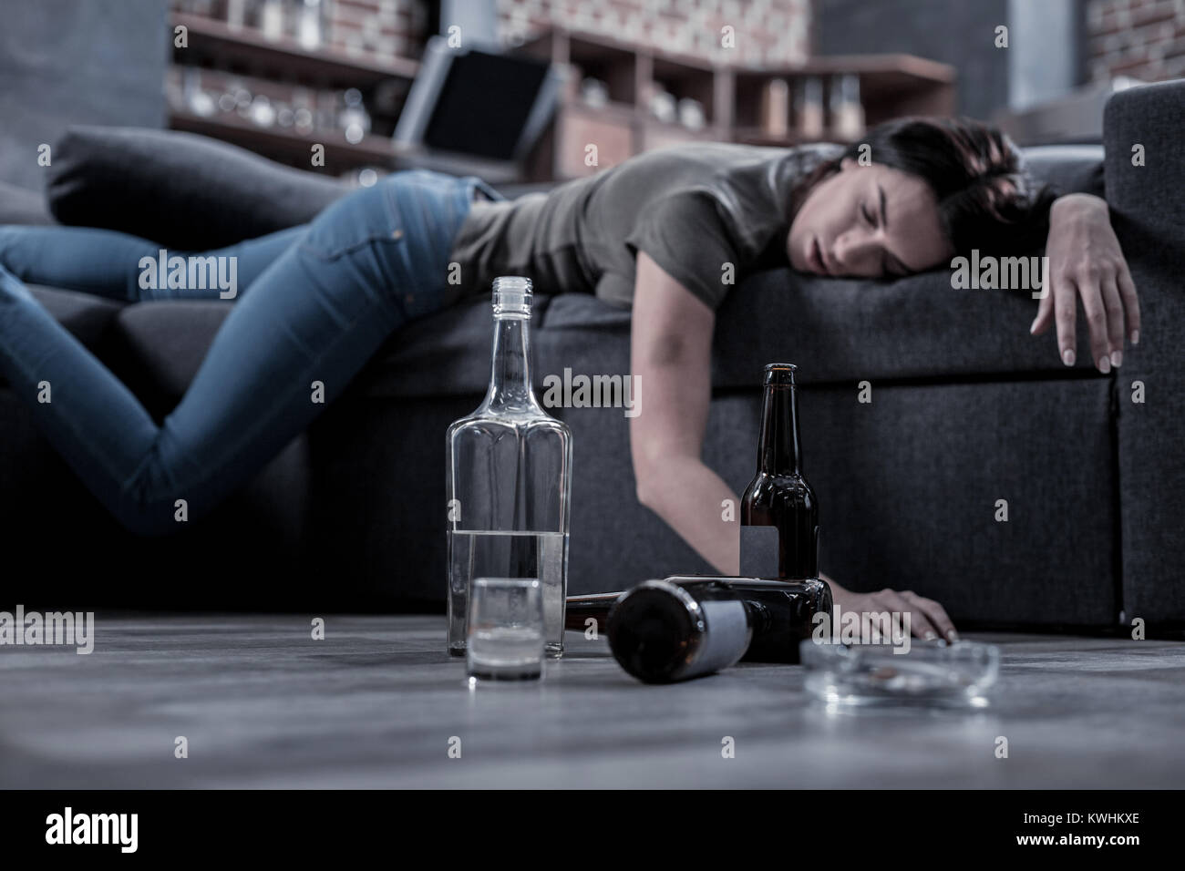 Half empty bottle of vodka standing on the floor Stock Photo