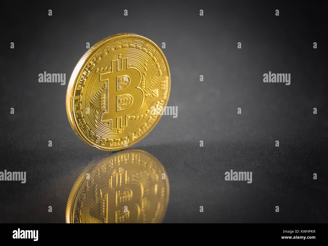 Cryptocurrency physical colored bitcoin coins. Golden bitcoin with grey background. Stock Photo