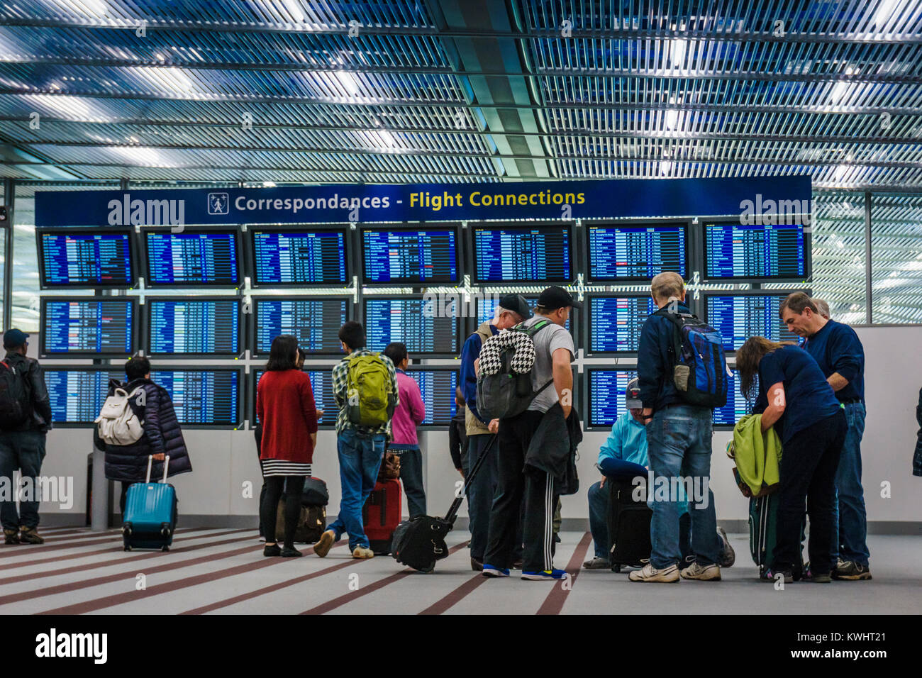 Passengers checking flight connections on monitors Stock Photo Alamy